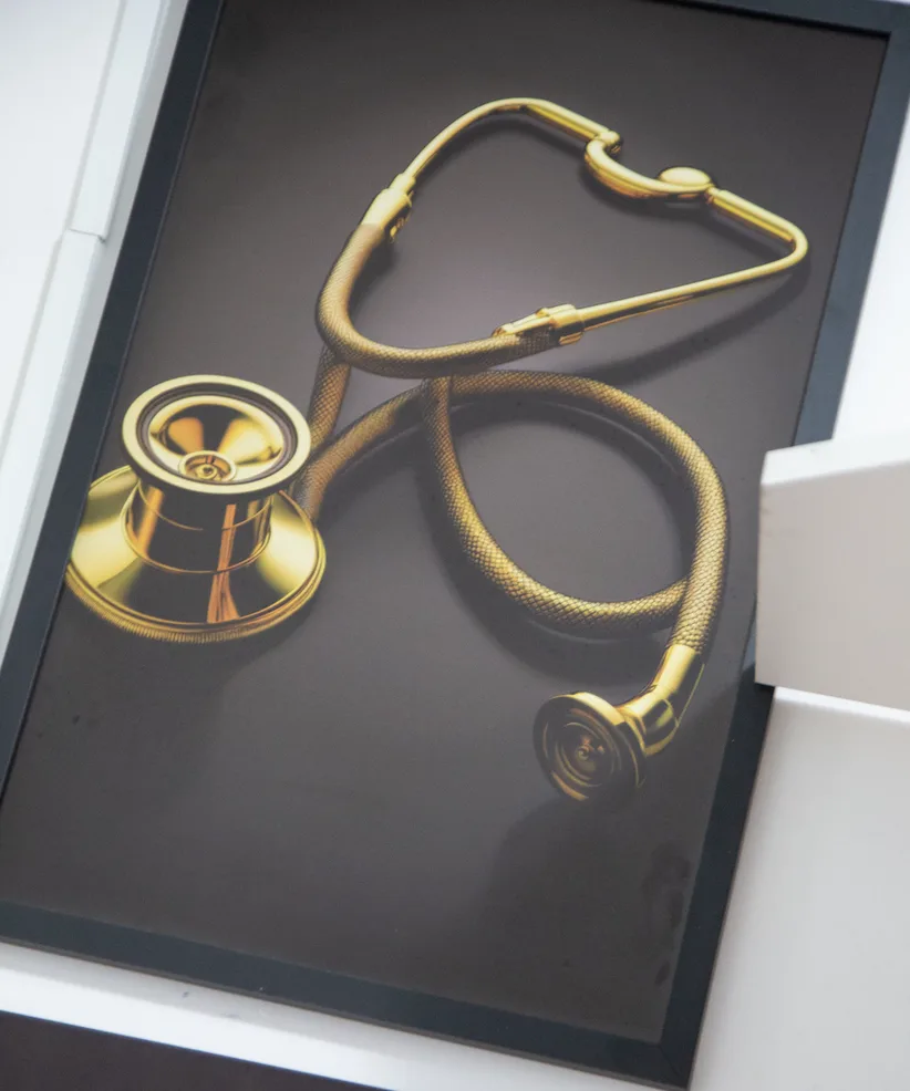 Quadro com estetoscópio dourado na parede da Clínica BerLaris