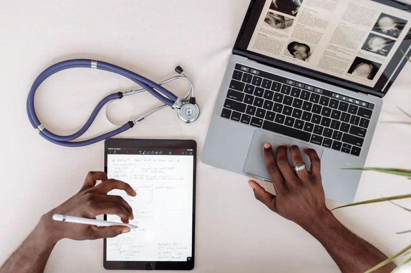 Tablet, laptop e estetoscópio sobre a mesa